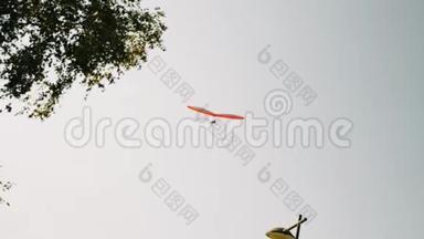 橙色孤立悬挂滑翔机在灰色多云的天空中飞行。 阿尔卑斯山的滑翔机飞行课程